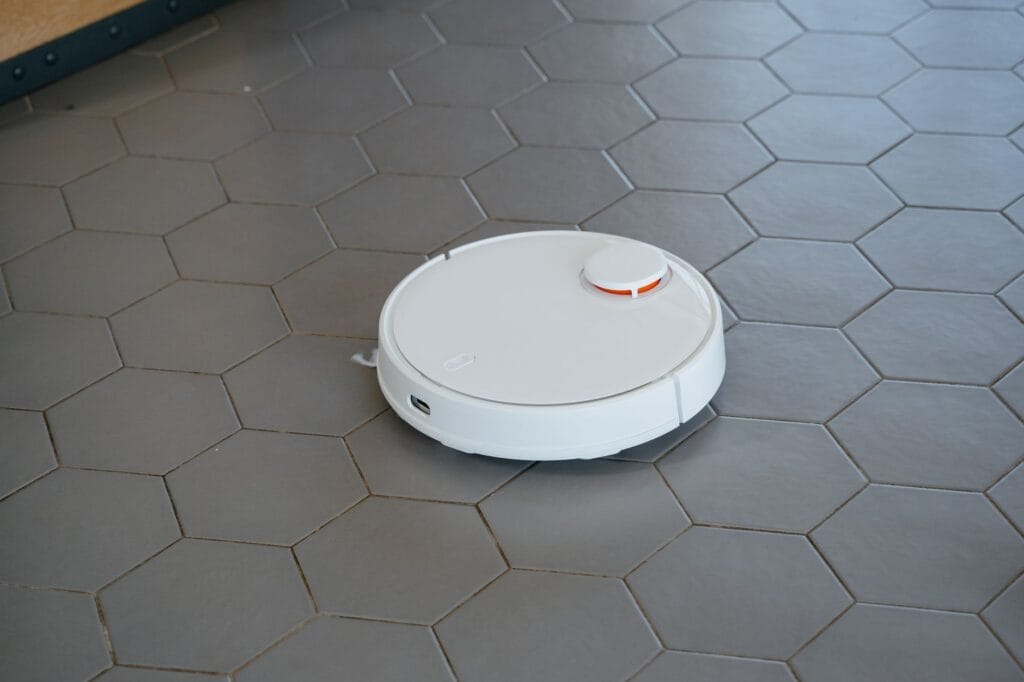 Biały robot sprzątający na sześciokątnej podłodze